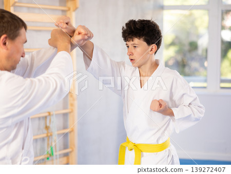 Man and teenage boy training karate fight 139272407