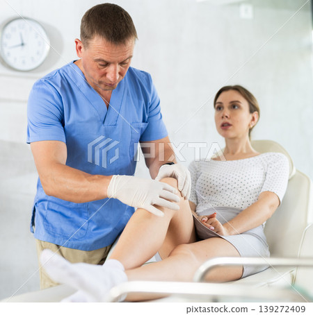 Woman complaining about leg pain to surgeon in clinic Woman complaining about leg pain to surgeon in clinic 139272409