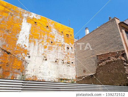 Exposed Building Side Wall with Yellow Protective Coating in Urban Area Exposed Building Side Wall with Yellow Protective Coating in Urban Area 139272512