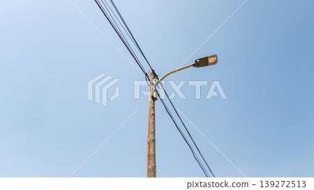 Aged Lamppost with Overhead Wires Under Clear Blue Sky Aged Lamppost with Overhead Wires Under Clear Blue Sky 139272513