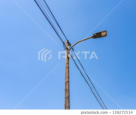 Old Street Lamp with Cables Against Blue Sky 139272514