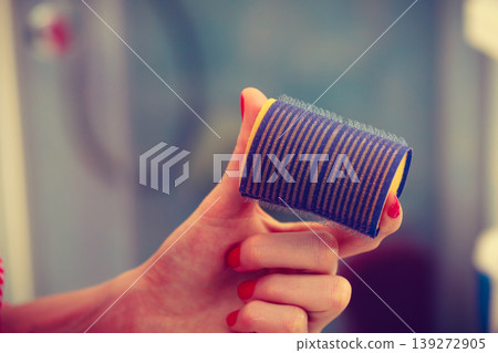 Woman holding hair rollers in bathroom 139272905