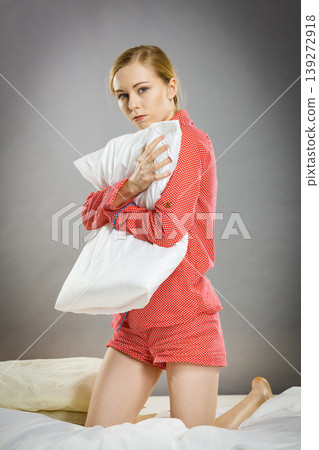 Sad depressed girl in bed gripping pillow Sad depressed girl in bed gripping pillow 139272918