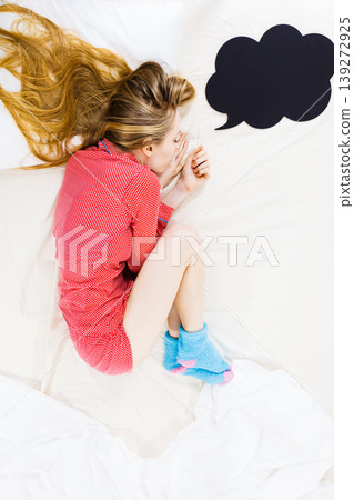 Young woman lying on bed wearing pajamas Young woman lying on bed wearing pajamas 139272925