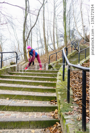 Sporty girl stretching outdoor in park. Sporty girl stretching outdoor in park. 139272934