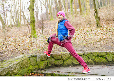 Sporty girl stretching outdoor in park. Sporty girl stretching outdoor in park. 139272937