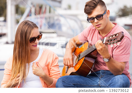Girl charmed by musican. 139273012