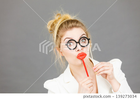 Happy elegant woman holding carnival accessoies on stick Happy elegant woman holding carnival accessoies on stick 139273034