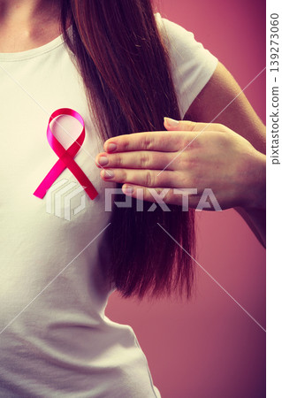 Pink ribbon on woman chest to support breast cancer cause Pink ribbon on woman chest to support breast cancer cause 139273060