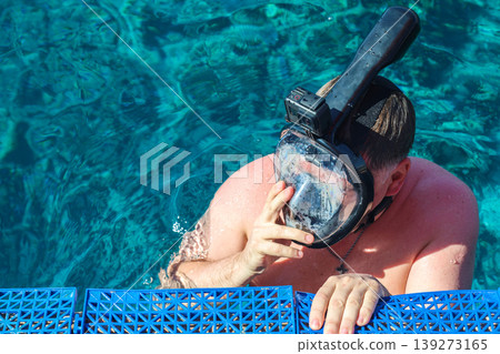Adventurous Man Snorkeling in the Red Sea with a Snorkel Mask and Action Camera, Exploring Vibrant Marine Life and Underwater Wonders 139273165