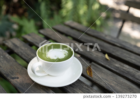 Matcha latte, on grunge wooden table, cozy atmosphere in the backyard garden 139273270