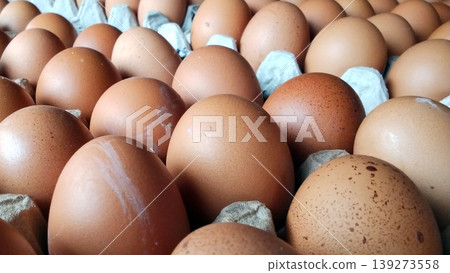 Close-up image of fresh chicken eggs in a cardboard tray. 139273558