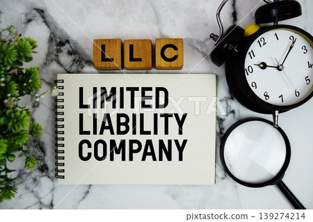 LLC Limited Liability Company text with alarm clock and magnifying glass on marble background LLC Limited Liability Company text with alarm clock and magnifying glass on marble background 139274214
