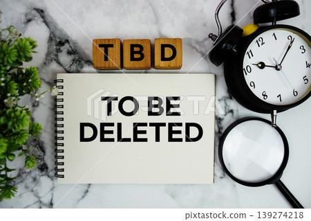 TBD To Be Deleted text with alarm clock and magnifying glass on marble background TBD To Be Deleted text with alarm clock and magnifying glass on marble background 139274218