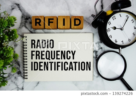 RFID Radio Frequency Identification text with alarm clock and magnifying glass on marble background RFID Radio Frequency Identification text with alarm clock and magnifying glass on marble background 139274226