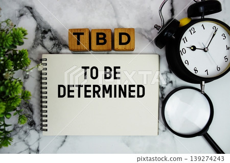 TBD To Be Determined text with alarm clock and magnifying glass on marble background TBD To Be Determined text with alarm clock and magnifying glass on marble background 139274243