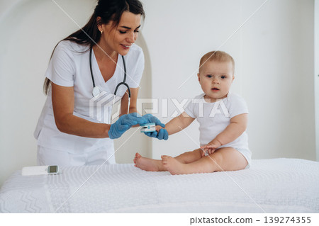 The oxygen in blood meter tool. Female doctor is taking care of little baby girl in the clinic 139274355