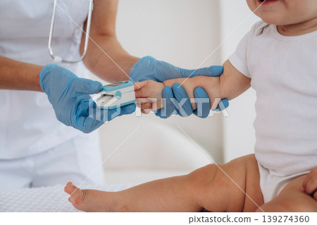 Routine check up. Female doctor is taking care of little baby girl in the clinic Routine check up. Female doctor is taking care of little baby girl in the clinic 139274360