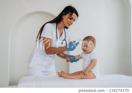 Woman is measuring the temperature. Female doctor is taking care of little baby girl in the clinic 139274370