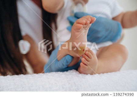 Close up view of little baby girl that is in appointment with doctor Close up view of little baby girl that is in appointment with doctor 139274390