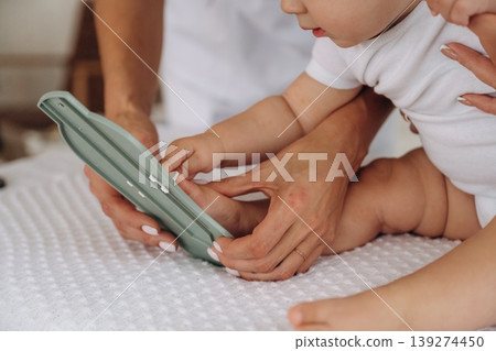 Board game, game for developing motor skills. Mother with her little baby daughter is in clinic with doctor at appointment Board game, game for developing motor skills. Mother with her little baby daughter is in clinic with doctor at appointment 139274450