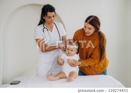 Mother with her little baby daughter is in clinic with doctor at appointment Mother with her little baby daughter is in clinic with doctor at appointment 139274453
