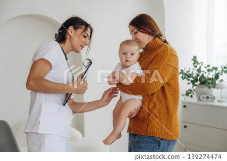 Consultation time. Mother with her little baby daughter is in clinic with doctor at appointment Consultation time. Mother with her little baby daughter is in clinic with doctor at appointment 139274474