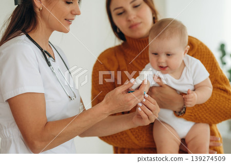 Medicine is in hands. Mother with her little baby daughter is in clinic with doctor at appointment Medicine is in hands. Mother with her little baby daughter is in clinic with doctor at appointment 139274509