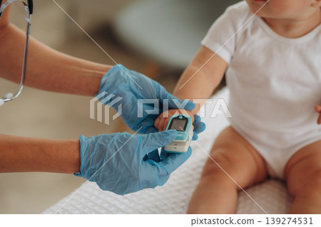 Oxygen content measuring. Close up view of little baby girl that is in appointment with doctor 139274531