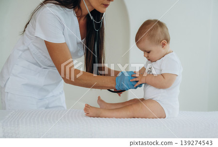 Stethoscope, professional equipment. Female doctor is taking care of little baby girl in the clinic Stethoscope, professional equipment. Female doctor is taking care of little baby girl in the clinic 139274543