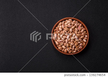 Salted pistachio nuts in shells as a healthy, high calorie food ingredient. Pistachio nuts 139274654