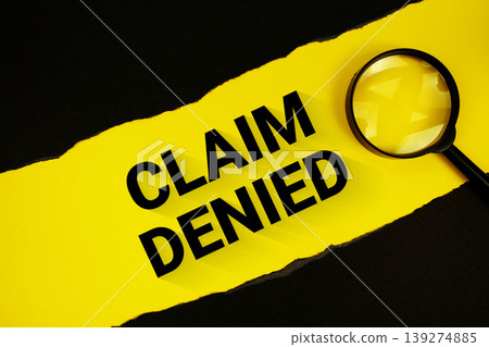 Claim Denied text on yellow with black paper torn ripped and magnifying glass Claim Denied text on yellow with black paper torn ripped and magnifying glass 139274885