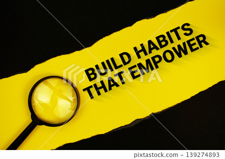 Build Habits That Empower text on yellow with black paper torn ripped and magnifying glass Build Habits That Empower text on yellow with black paper torn ripped and magnifying glass 139274893