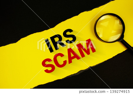 IRS Scam text on yellow with black paper torn ripped and magnifying glass IRS Scam text on yellow with black paper torn ripped and magnifying glass 139274915