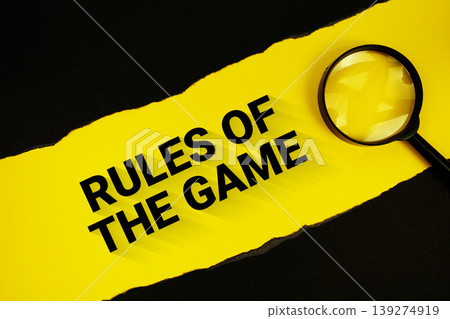 Rules Of The Game text on yellow with black paper torn ripped and magnifying glass Rules Of The Game text on yellow with black paper torn ripped and magnifying glass 139274919