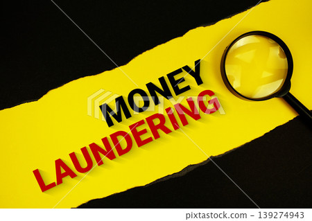 Money Laundering text on yellow with black paper torn ripped and magnifying glass Money Laundering text on yellow with black paper torn ripped and magnifying glass 139274943