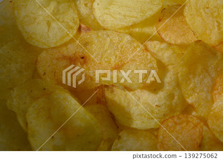Crispy golden chips scattered joyfully on a bright background celebrating snack time during a sunny afternoon Crispy golden chips scattered joyfully on a bright background celebrating snack time during a sunny afternoon 139275062