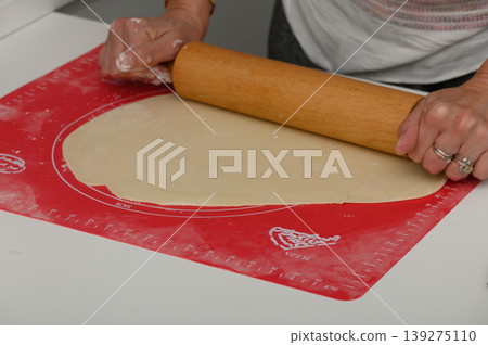 Rolling dough with care on a vibrant work surface during a joyful baking session at home Rolling dough with care on a vibrant work surface during a joyful baking session at home 139275110