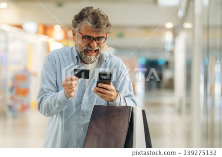 Process of online payment by using credit card and smartphone. Senior man is in the mall, shopping time conception 139275132
