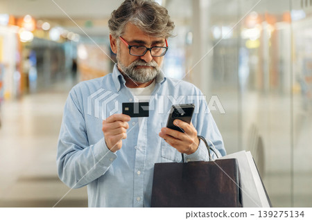 Process of online payment by using credit card and smartphone. Senior man is in the mall, shopping time conception 139275134