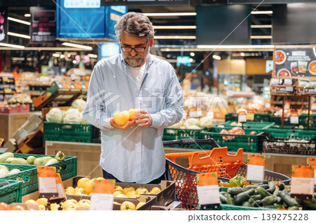 Vegetables section. A senior man is buying food in the grocery store Vegetables section. A senior man is buying food in the grocery store 139275228