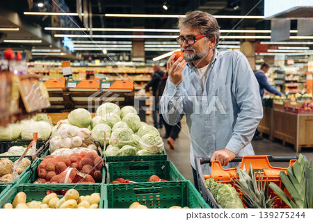 A senior man is buying food in the grocery store A senior man is buying food in the grocery store 139275244