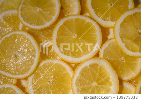 Slices of fresh lemons arranged beautifully on a bright surface capturing 139275338