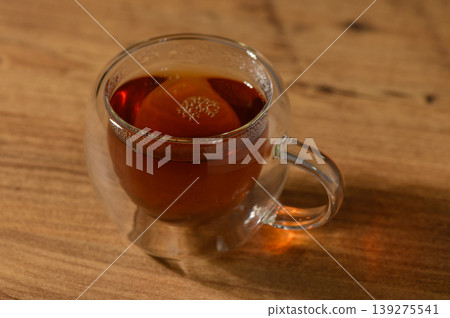 A warm cup of herbal tea sits gracefully on a rustic wooden table in a tranquil afternoon setting A warm cup of herbal tea sits gracefully on a rustic wooden table in a tranquil afternoon setting 139275541
