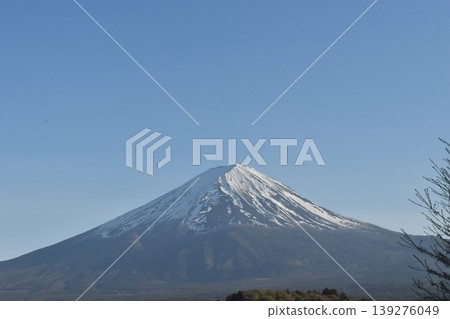 Snowcapped Fuji mountain peak under clear blue sky with calm winter landscape and distant ridge 139276049
