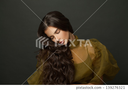 Young woman hair. Beautiful model with long curly hairstyle posing Young woman hair. Beautiful model with long curly hairstyle posing 139276321