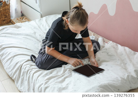 Teenager boy using pc tablet and playing. Kid at home Teenager boy using pc tablet and playing. Kid at home 139276355