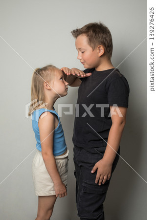 Kids Growth concept. Length height measurement. Children, young boy and girl together Kids Growth concept. Length height measurement. Children, young boy and girl together 139276426