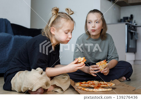 Children friends girl and boy eating pizza at home Children friends girl and boy eating pizza at home 139276436