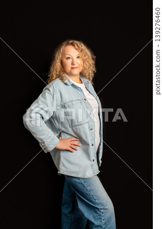 Mature woman in casual denim shirt posing with hand on hip. Successful business owner. Business portrait of designer, businesswoman, successful woman 56 years old Mature woman in casual denim shirt posing with hand on hip. Successful business owner. Business portrait of designer, businesswoman, successful woman 56 years old 139276460